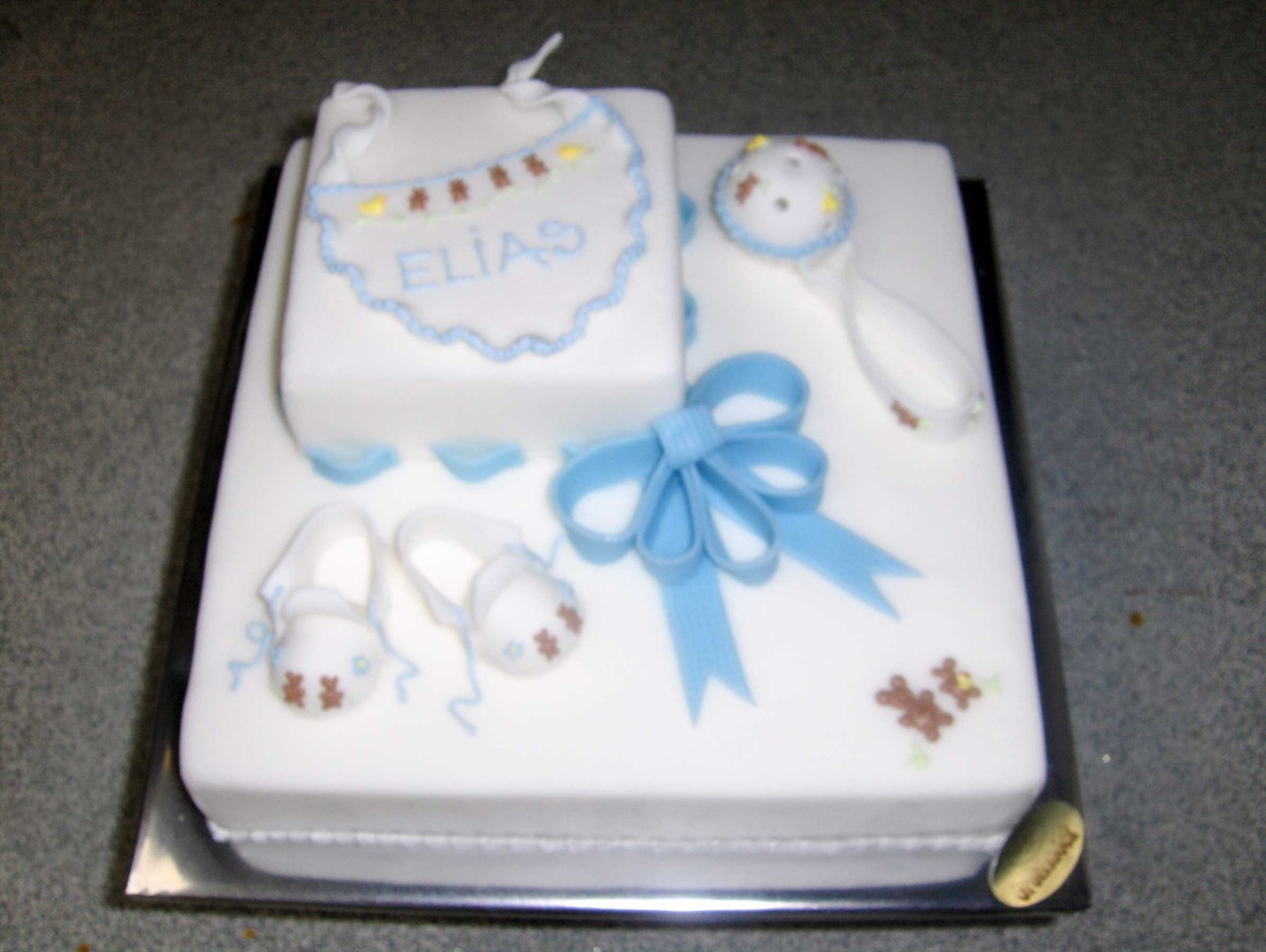 Tauftorte mit Rassel und Babyschuhen Tauftorte mit Rassel und Babyschuhen